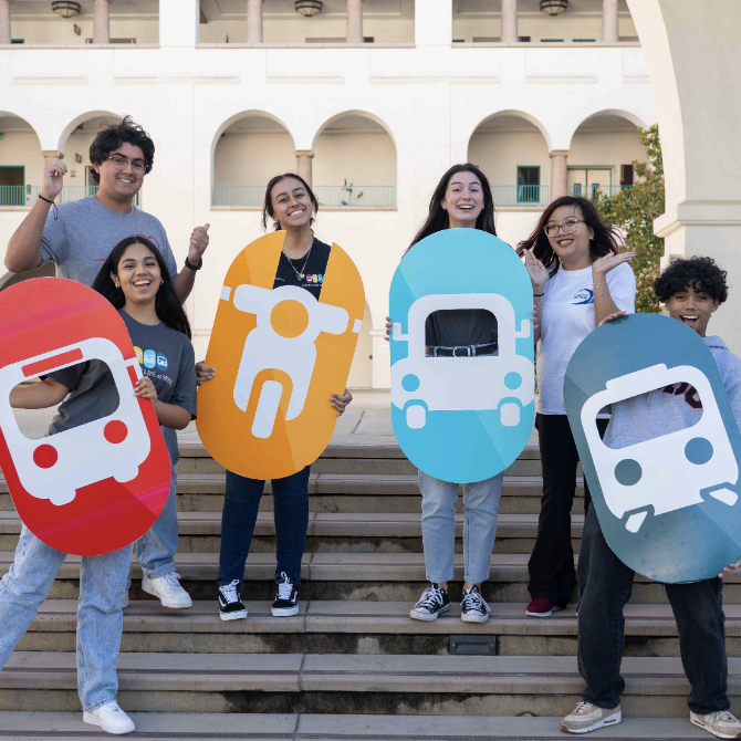 students holding poster images of transportation vehicles