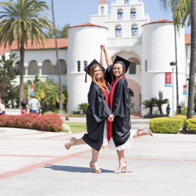 graduates posing in front of hepner hall