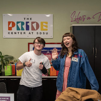 people greeting in front of the pride center sign